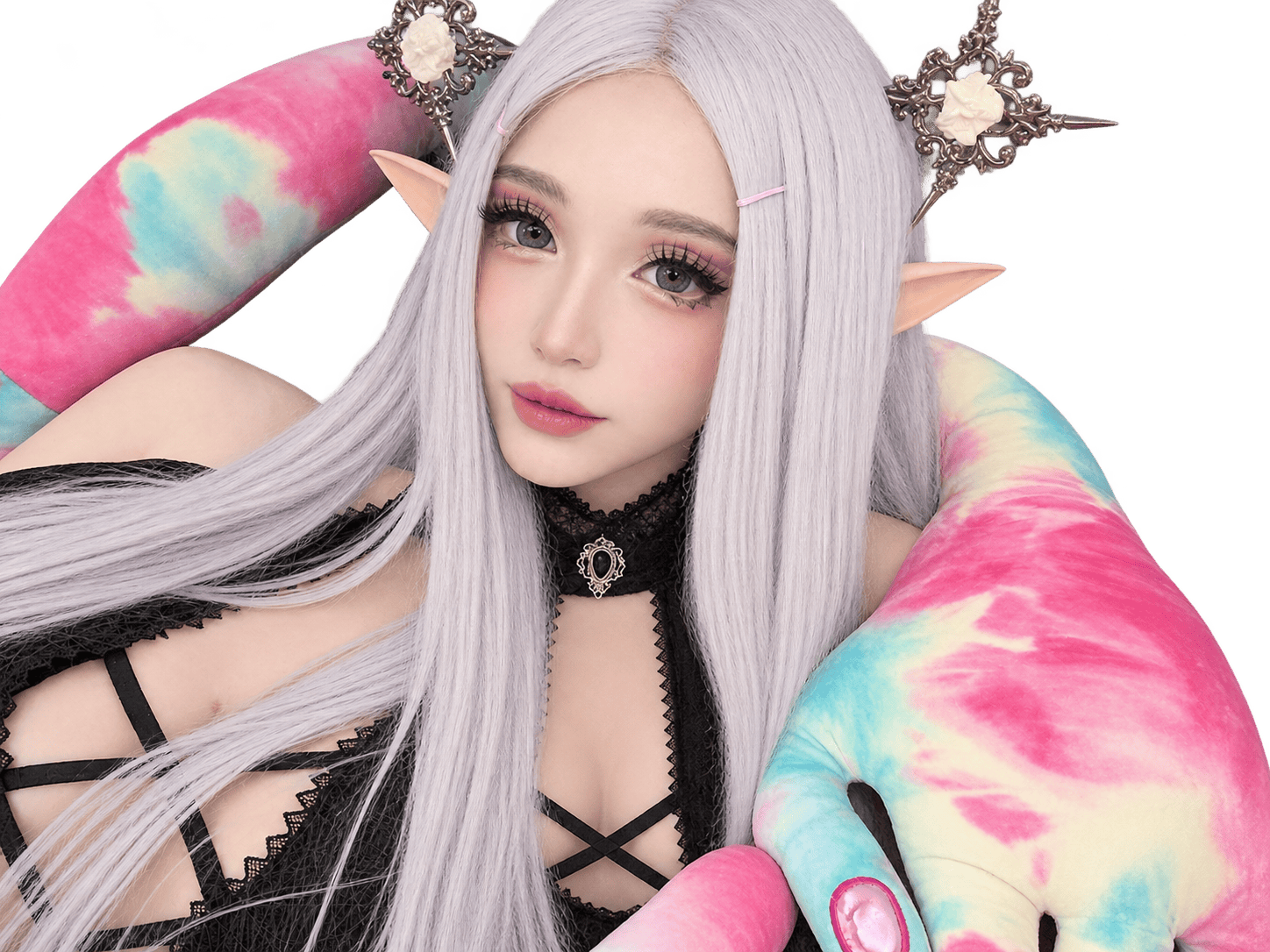 Silver-haired elf cosplayer with pointed ears, ornate rose headpieces, and a black gothic outfit, nestled among oversized pastel pink and turquoise tentacles.